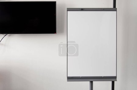 Photo for White board or flipchart on white wall background. Background, place for text, copy space. - Royalty Free Image