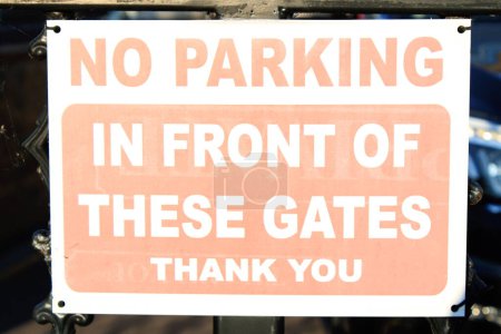 Photo for Worn White and red parking sign "No Parking in front of these gates Thank you" - Royalty Free Image