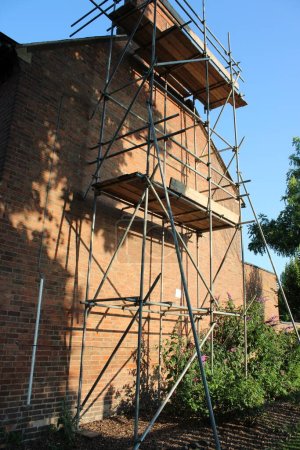Photo for Scaffolding erected against a residential building clear blue sky - Royalty Free Image