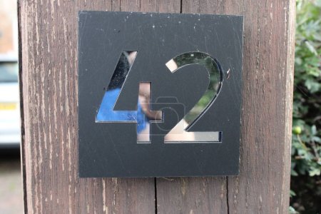 Photo for Door number 42 black background and silver reflective surface - Royalty Free Image