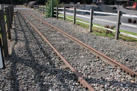 Téléchargez les photos : Ligne de tramway avec voies de tramway en fer surélevé, enceinte en gravier et clôture - en image libre de droit