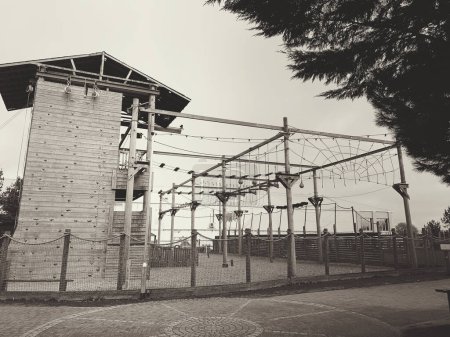 Photo for Monochrome picture of climbing wall and high ropes course with tree overhanging - Royalty Free Image