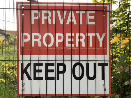 Photo for Red and white sign "private property Keep out" attached to a metal fence - Royalty Free Image