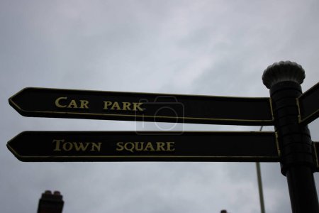 Up close picture of directional sign post "Car Park" "Town Square"