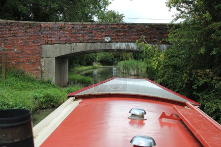 Schmales Boot auf einem Kanal mit Brücke voraus, Bild aus der Sicht der Boote