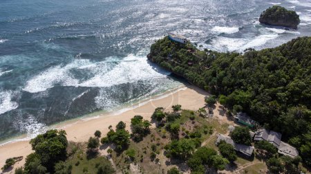 Téléchargez les photos : La vue aérienne lointaine de Boat Hill est prise de Goa Cina Beach en Indonésie - en image libre de droit