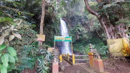 Foto de Malang, Indonesia - 22 de julio de 2022: La entrada a la cascada de Grojogan Sewu, que tiene 2 estatuas, se encuentra en Pujon, Java Oriental, Indonesia - Imagen libre de derechos