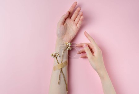 Creative beauty photo hand girls with flowers on pastel pink background