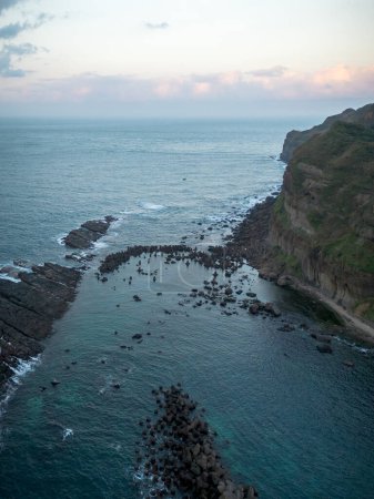 Photo for Aerial view of sunset at Bitoujiao lighthouse, a famous scenery of Taiwan northeast corner. Birds eye view in Bitoujiao cape, Ruifang district, New Taipei, Taiwan. - Royalty Free Image
