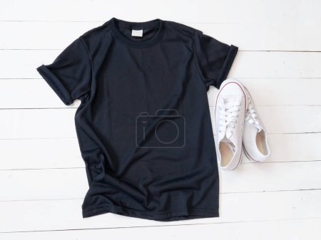 Photo for Black T Shirt mockup weathered and canvas shoes on white wood background shirt template - Royalty Free Image