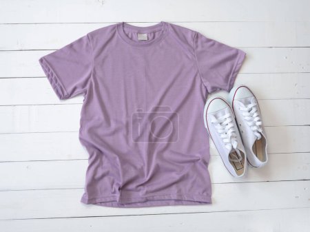 Foto de Camiseta púrpura maqueta resistido y zapatos de lona en plantilla de camisa de fondo de madera blanca - Imagen libre de derechos