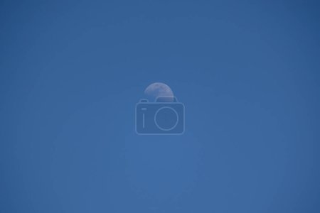 Une vue de la lune avec un ciel bleu dans la journée.