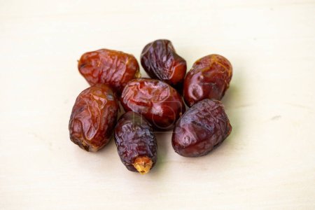 Organic dried dates or palm fruit on a wooden background