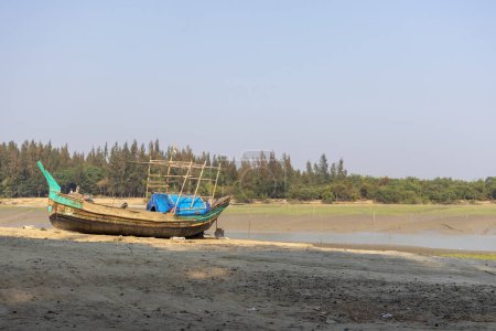Barco de pesca en la playa. Se coloca en la orilla del mar en la marea baja. Este lugar es conocido como Noakhali Musapur Closer o Musapur Sea Beach en Bangladesh.