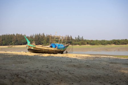 Barco de pesca local en la playa. Se coloca en la orilla del mar en la marea baja. Este lugar es conocido como Noakhali Musapur Closer o Musapur Sea Beach en Bangladesh.