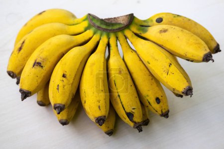 Ein Bündel frischer reifer gelber Bananen auf einem hölzernen Hintergrund. Bananen sind gesunde Früchte. Es enthält Kalium, Magnesium, Vitamin B6, Ballaststoffe, Tryptophan und Antioxidantien.