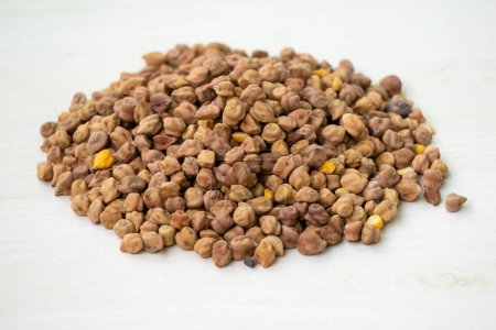 Fresh raw chickpea or chick pea on a white wooden background. Locally in Bangladesh, it is called Chola Boot and also known as Bengal gram, chana, channa, garbanzo bean, Indian pea, or Egyptian pea.
