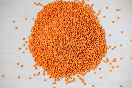 Masoor Dal is isolated over a wooden textured background. It is also called red lentil. Incorporating red lentils into your diet can help you easily meet fiber and protein needs.