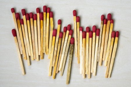 Many match sticks on wooden textured background. Matchsticks are very useful to start a fire, light up a candle, burn paper, etc. It is a short, slender piece of flammable wood used in making matches.
