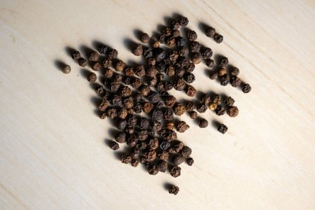 Black pepper isolated on a wooden background. It has many health benefits. Black pepper is a low-calorie spice that adds flavor to food without adding extra calories.