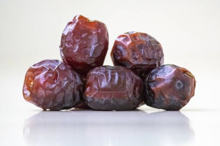 Delicious fresh date palm fruits or kurma on a wooden background. Locally in Bangladesh, it is called Khejur. Dates are high in fiber and antioxidants.