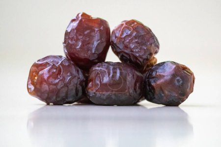Fresh sweet date palm fruits or kurma on a wooden background. Locally in Bangladesh, it is called Khejur. Dates are high in fiber and antioxidants.