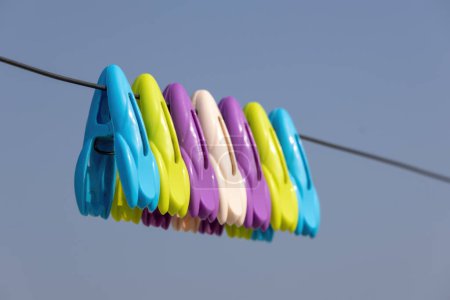 Foto de Pinzas de tela multicolores en el tendedero con fondo de cielo azul claro. - Imagen libre de derechos