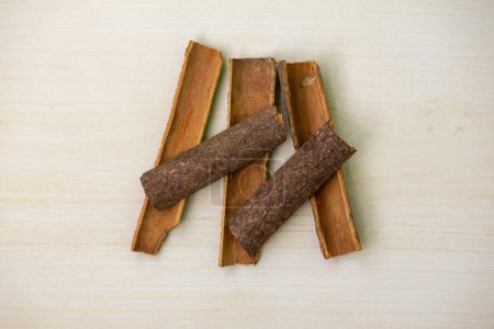 Cinnamon sticks on a wooden background. Aromatic condiment for cooking. It is also known as darchini, daruchini, dalchini, cinnamon quills, cassia bark, cinnamon twig, or cassia aromaticum.