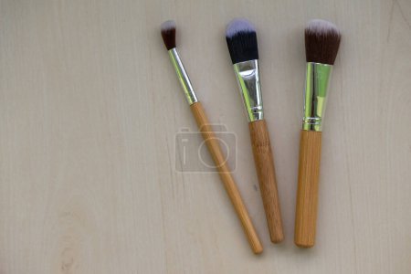 Cosmetic makeup brushes are isolated on a wooden background. Women's Beauty care concept.