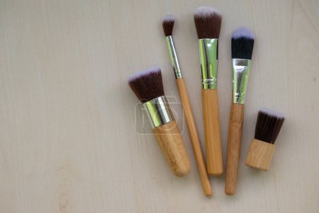 Makeup brushes are isolated on a wooden background. Blush, eyeshadow contour, foundation, concealer bronzer, angled brushes. makeup brush set. Beauty concept.