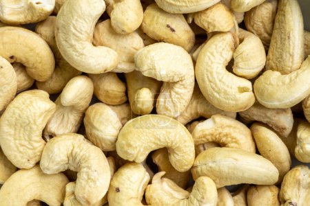 Cashew nuts as background. Top view. In the Bengali language, it is called Kaju Badam. Its scientific name Anacardium occidentale. Cashews are high in fiber, heart-healthy fats, and plant protein.