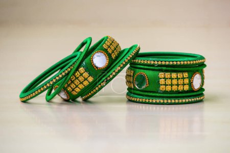 A pair of colorful bangles on a blurred background. Beautiful jewelry for women. Handmade bangles decorated with silk thread, mirror cut, and beads.