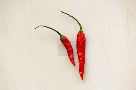 Hot red chili or ripe chilli pepper isolated on wooden background.