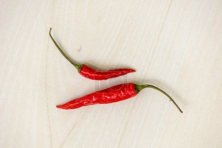 Fresh red hot chili peppers or ripe chillies on wooden background.