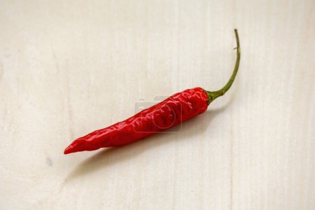 Red hot chili peppers or ripe chilli on wooden surface