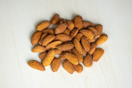 Almond nuts isolated on a wooden background. Almonds are a healthful food. Locally in Bangladesh, it is called Kath Badam. 