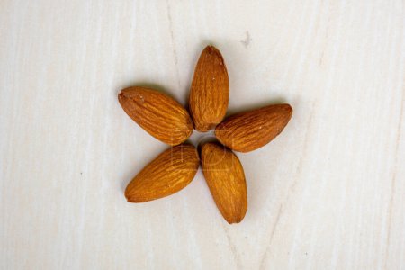 Decorated almonds on wooden background. In the Bengali language, it is called Kath Badam. 