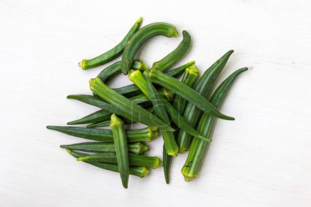 Pile of fresh lady's finger or okra isolated on white background. Its scientific name is Abelmoschus esculentus and also known as Bhendi, Dherosh, Bhindi, Vendi.