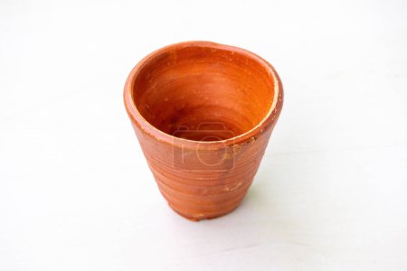 Téléchargez les photos : Une tasse d'argile vide sur fond blanc. Belle théière traditionnelle en terre. - en image libre de droit
