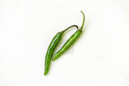 Fresh green chili peppers on a white background.