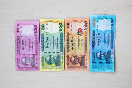 Bangladesch Bank Taka Papiergeld Währung isoliert auf Holzgrund. Bangladeschische BDT-Banknoten mit 10, 20, 50 und 100 Taka.