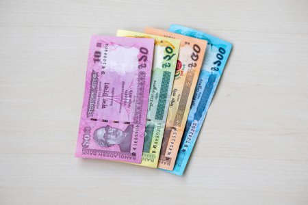Bangladesch Bank Taka Papiergeldwährung auf Holzgrund. Bangladeschische BDT-Banknoten mit 10, 20, 50 und 100 Taka.