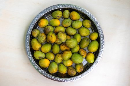 A steel plate full of fresh fruits ripe mangoes. Top view.