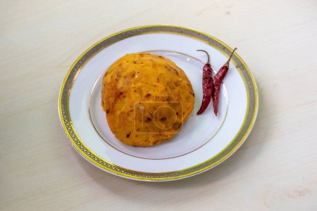 Delicioso Aloo Bhorta en un plato blanco sobre un fondo de madera. Alu Vorta es una comida tradicional de Bangladesh y la región de Bengala de la India..