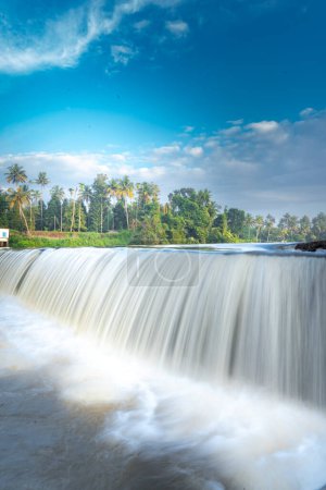 A beautiful view of a waterfall from a check dam In Kerala, India. A landscape view with pure white water flowing in a river