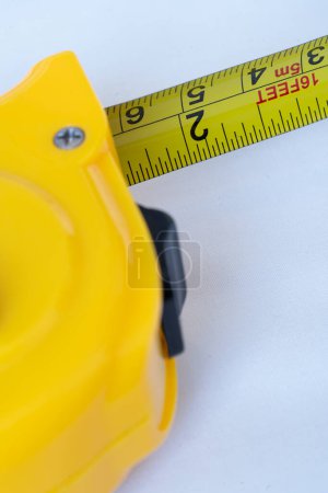 Téléchargez les photos : Ruban à maesure métallique en acier macro couleur jaune dans une table - en image libre de droit