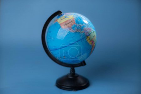 Téléchargez les photos : Stop motion du globe tournant isolé sur fond bleu. - en image libre de droit