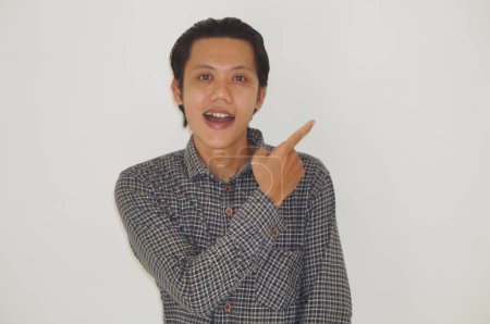 Photo for Young asian man wearing black shirt smiling pointing with hand finger to the side - Royalty Free Image