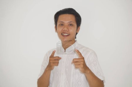 Foto de Joven asiático hombre vistiendo blanco camisa feliz y sonriendo por apuntar a la cámara - Imagen libre de derechos