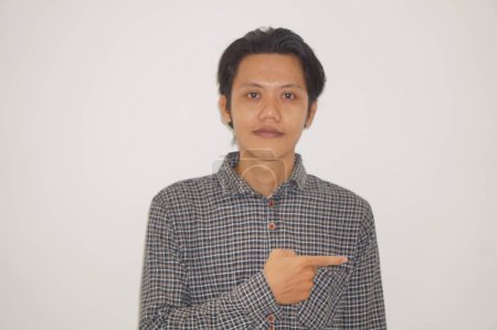 Photo for Young asian man wearing black shirt smiling pointing with hand finger to the side. - Royalty Free Image